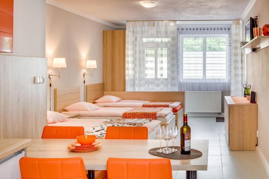 - un salon avec une table et des chaises orange dans l'établissement Apartements Studio 964, à Líbeznice
