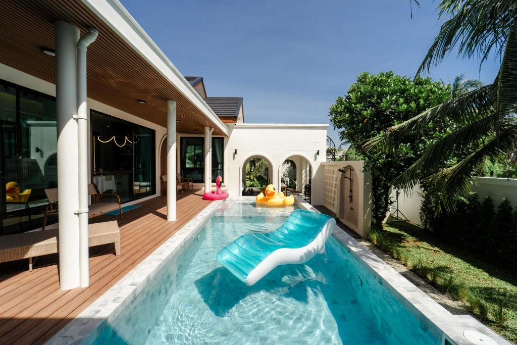 a swimming pool with a inflatable pool noodle in a house at PHUM Villa Songkhla in Ban Saphan Yao