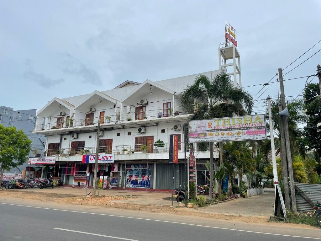 a large white building on the side of a street at Thisha Hotel & Restaurant in Jaffna