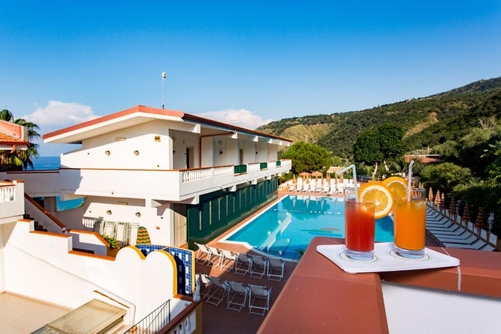- une vue sur un hôtel avec une piscine et des boissons dans l'établissement Hotel Santa Lucia, à Parghelia