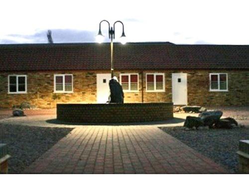 a building with a statue in the middle of a courtyard at Falcons Nest in Woodhurst