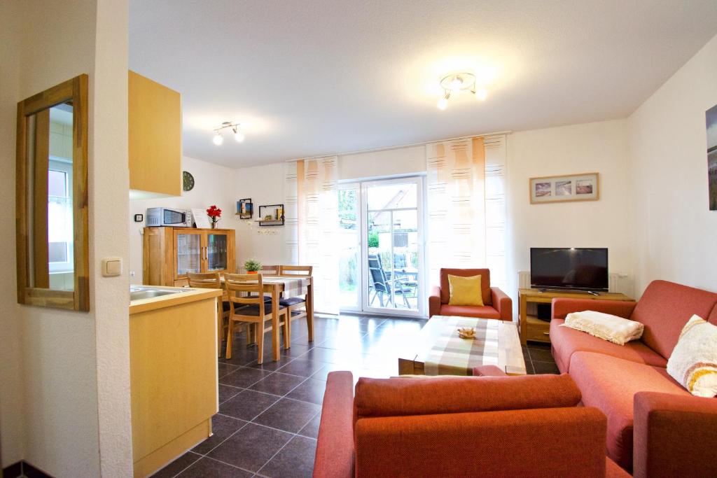 a living room with a red couch and a kitchen at Störtebeker in Norddeich