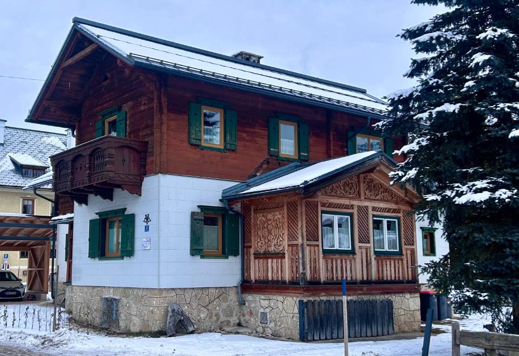 a large wooden house with snow on it at Ferienwohnung Feicht`n Schuster in Gosau