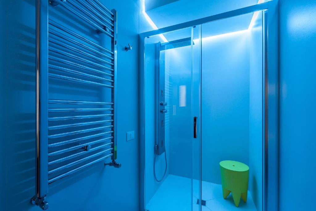 a bathroom with blue lighting and a glass shower at B&B Portorosso in Monopoli