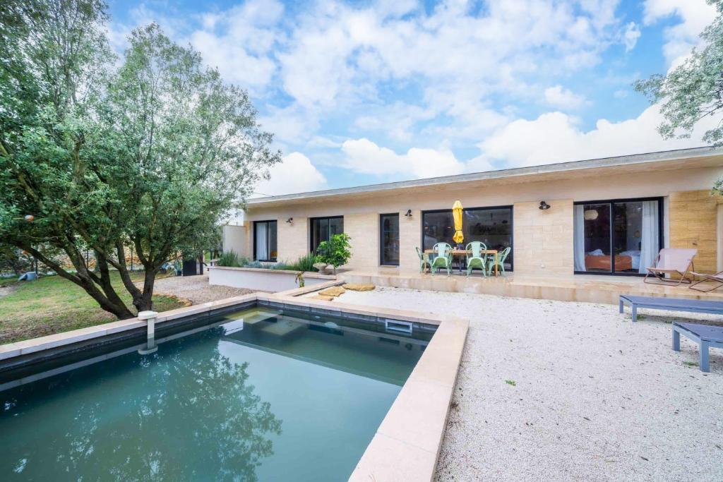 a house with a swimming pool in the backyard at Maison Jeannot - Climatisée avec piscine in Vers Pont du Gard