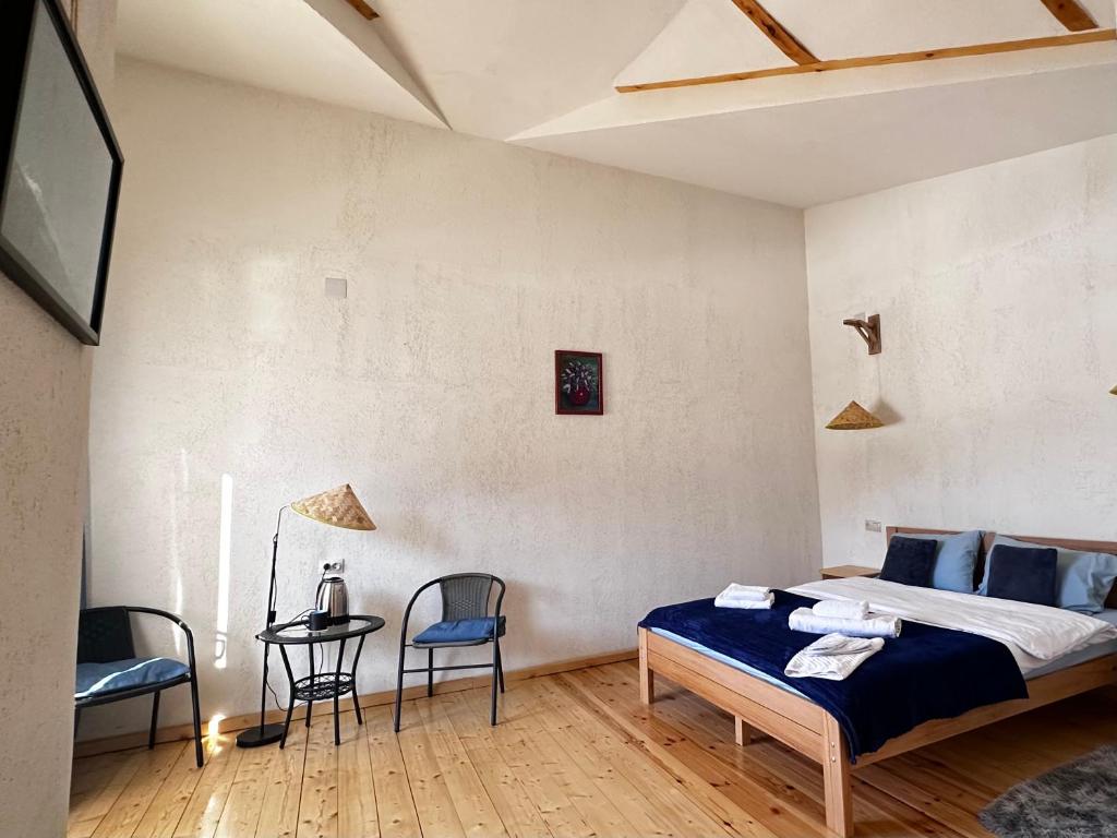 a bedroom with a bed and a table and chairs at "White House Nakani" - Guesthouse near the centre in Mestia