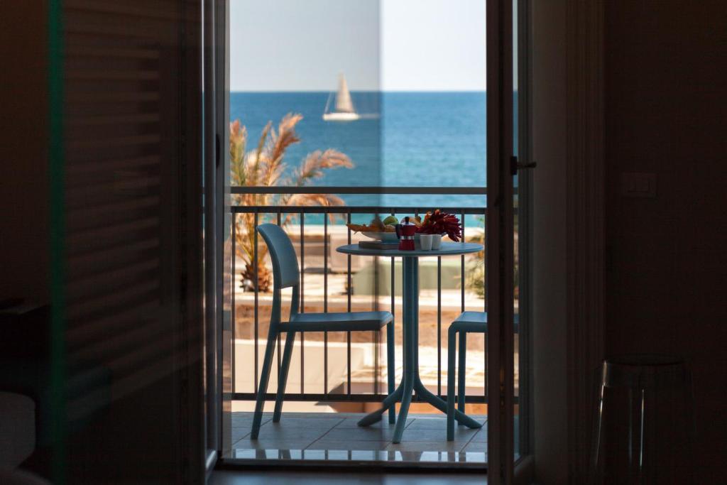 una mesa y sillas en un balcón con vistas al océano en B&B Portorosso en Monopoli