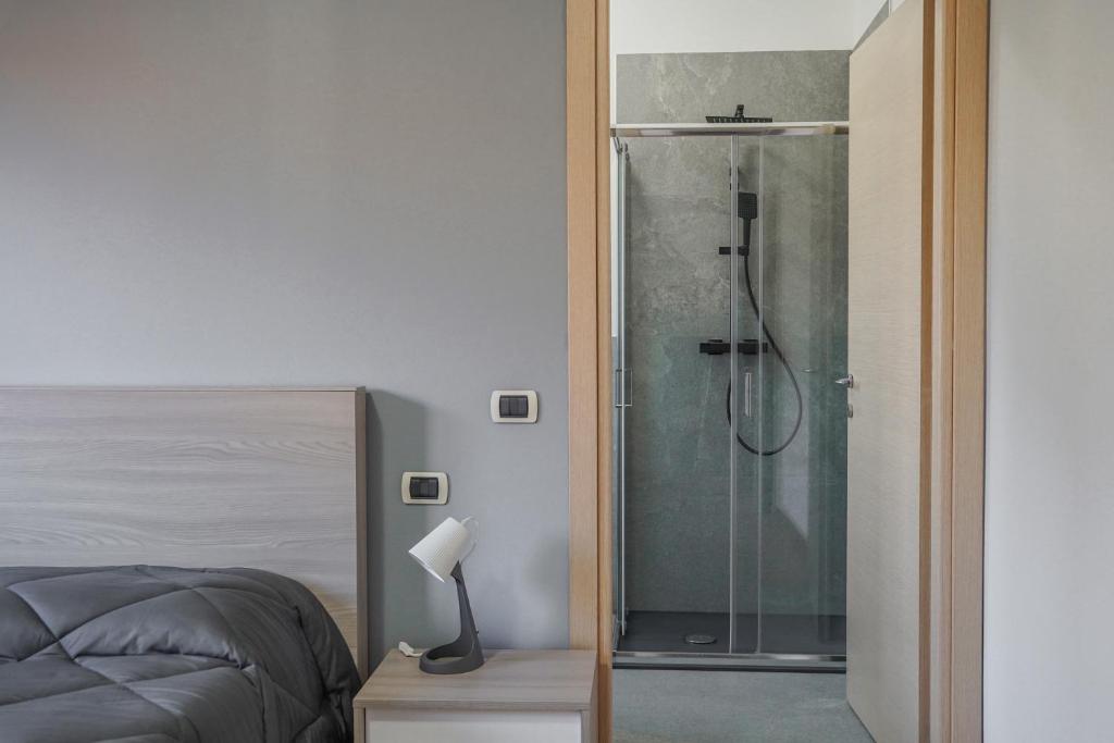 a glass shower in a bedroom with a bed at B&B dolcenotte in Gattico