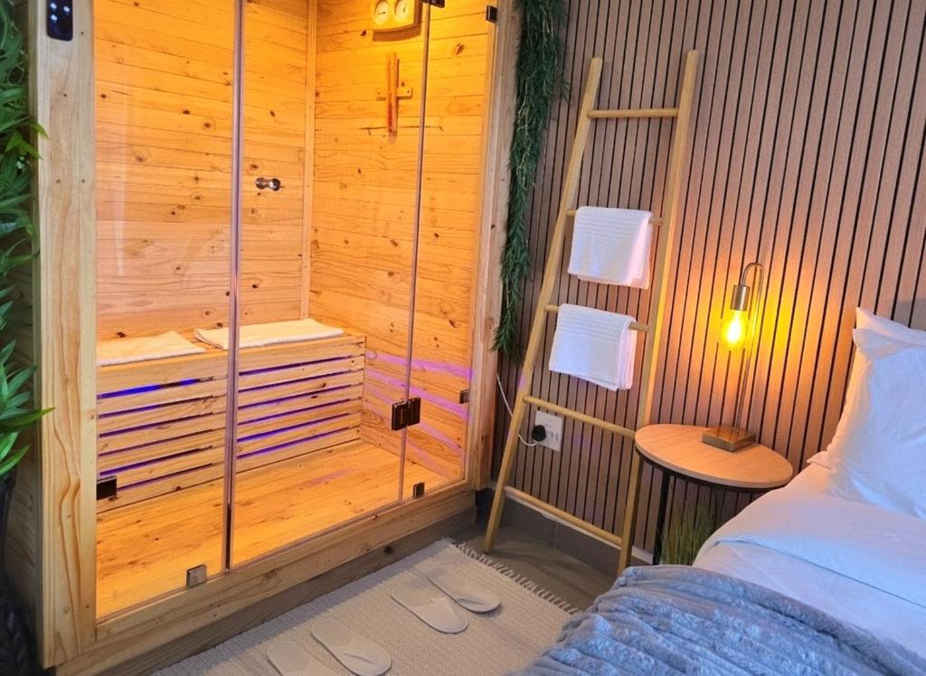 a bedroom with a sauna with a bed and a table at Luxury Spa unit, Private Sauna, Central Ballito in Ballito