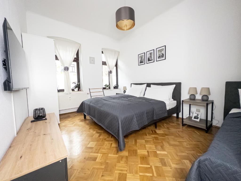 a bedroom with a bed and a wooden floor at Erstklassige 3-Zimmer Wohnung in Leipzig