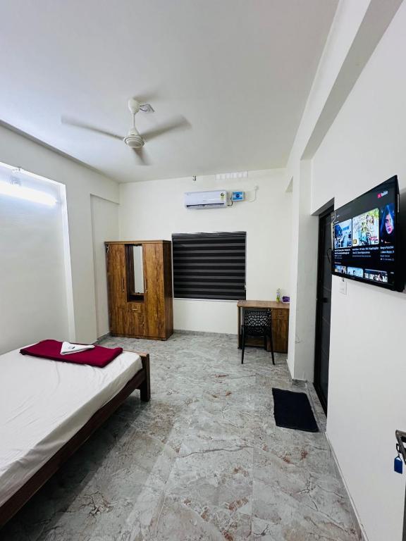 a bedroom with a bed and a flat screen tv at Dubai Inn in Kanjirapalli
