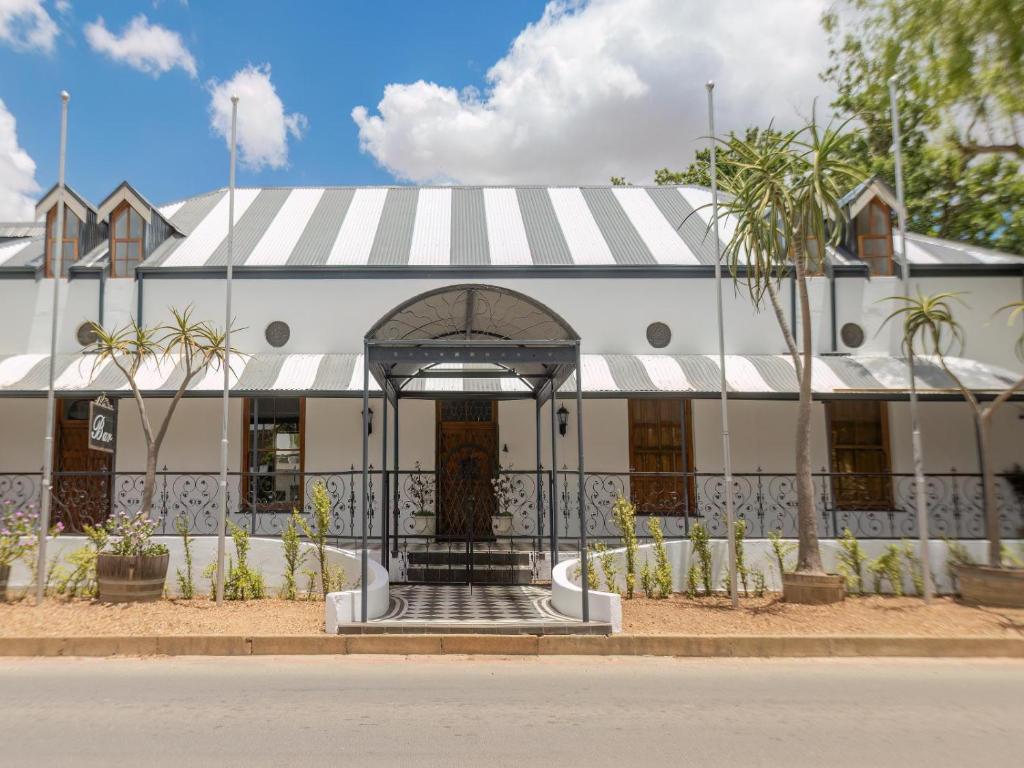 a white building with a striped awning at The Tin Roof in Riebeek-Kasteel