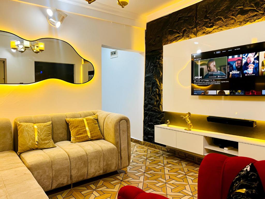 a living room with a couch and a flat screen tv at Perfect Home in Lagos