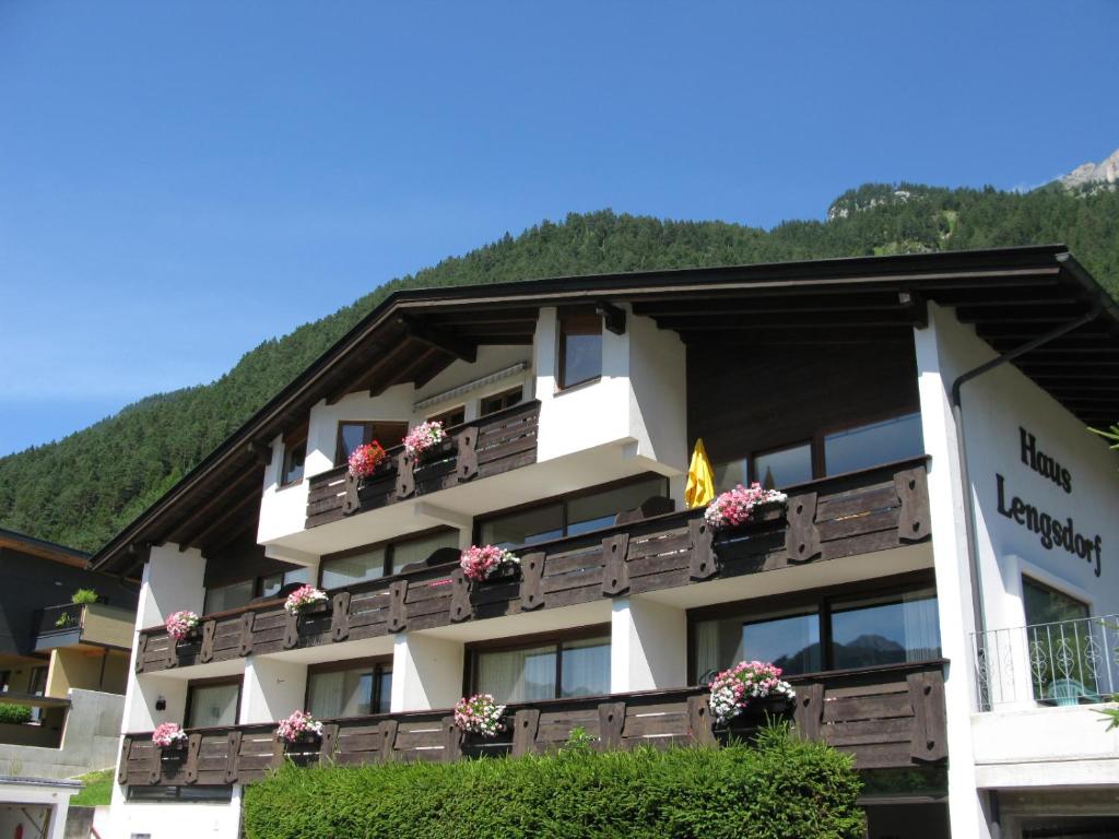 a hotel in the mountains with flowers on balconies at Appartementhaus Lengsdorf in Maurach