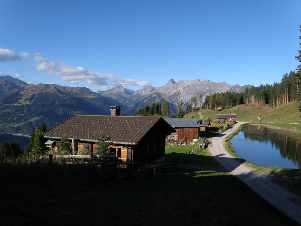a house with a lake and mountains in the background at Ferienhaus Fritzensee in Bartholomäberg