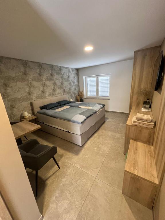 a bedroom with a bed and a table and a chair at Korantov Hram in Bukovci