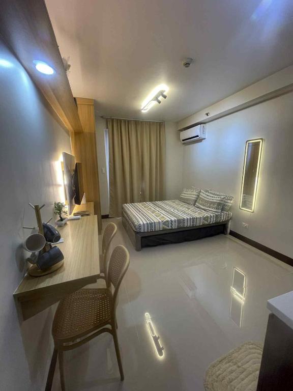 a room with a bed and a table and chairs at Affordable Condo Unit in Saekyung Phase 3 in Suba