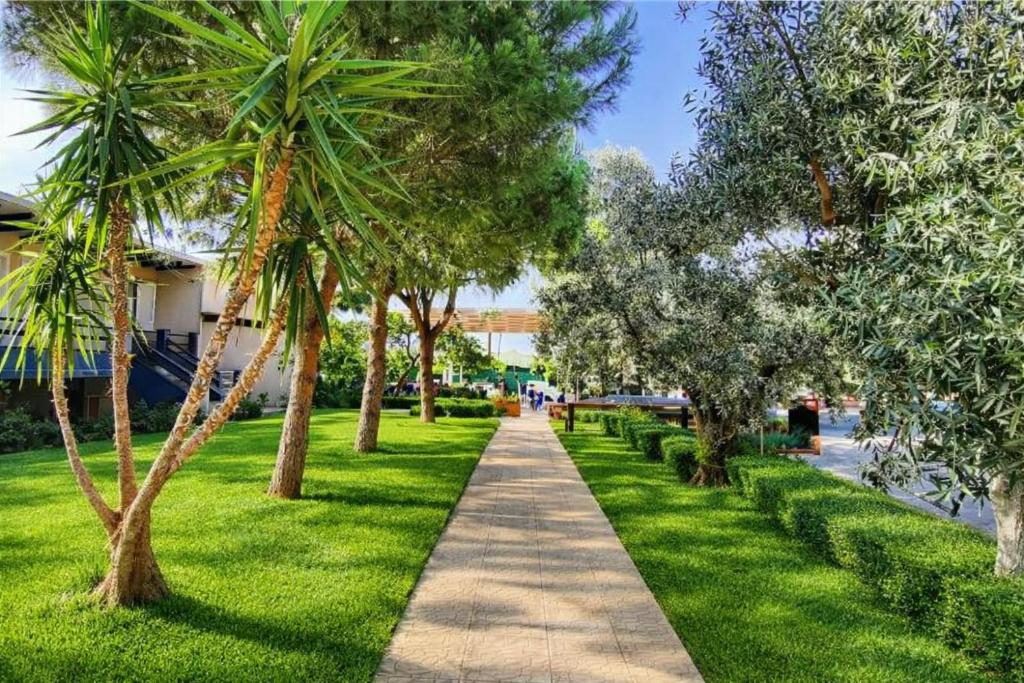 a path through a park with palm trees and grass at Villa Park Luxury Rooms in Paralio Astros