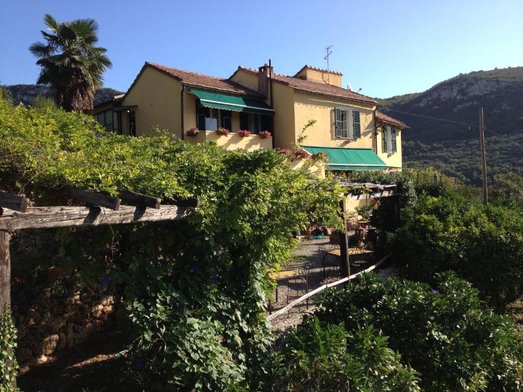 uma casa numa colina com arbustos à sua frente em Ai Cinque Campanili em Finale Ligure