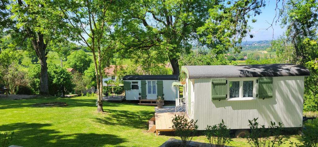 a small white caravan in a yard with trees at Petit a Petit - gypsy wagons and Bell tents in the Bourgogne in Saisy