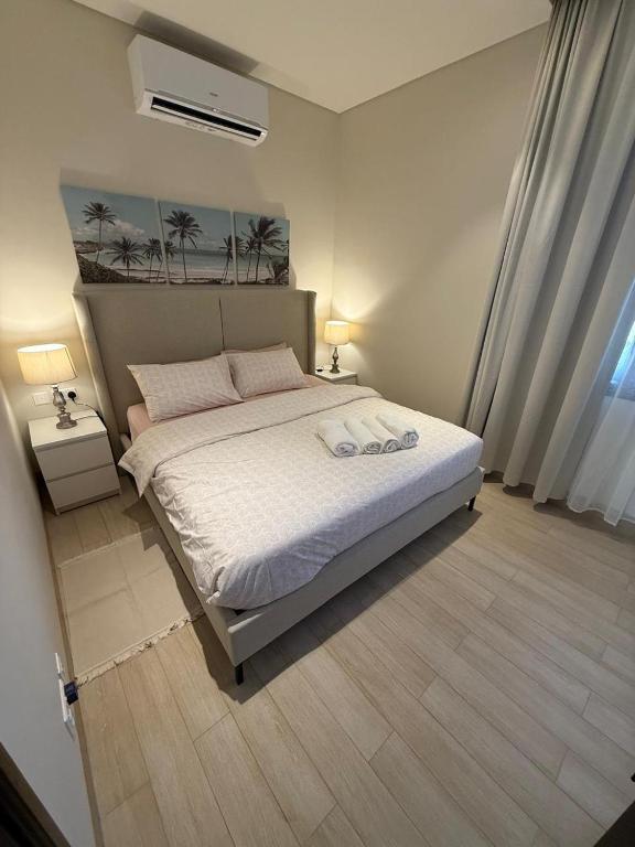 a bedroom with a large bed with white sheets at Sunset Hawana in Salalah