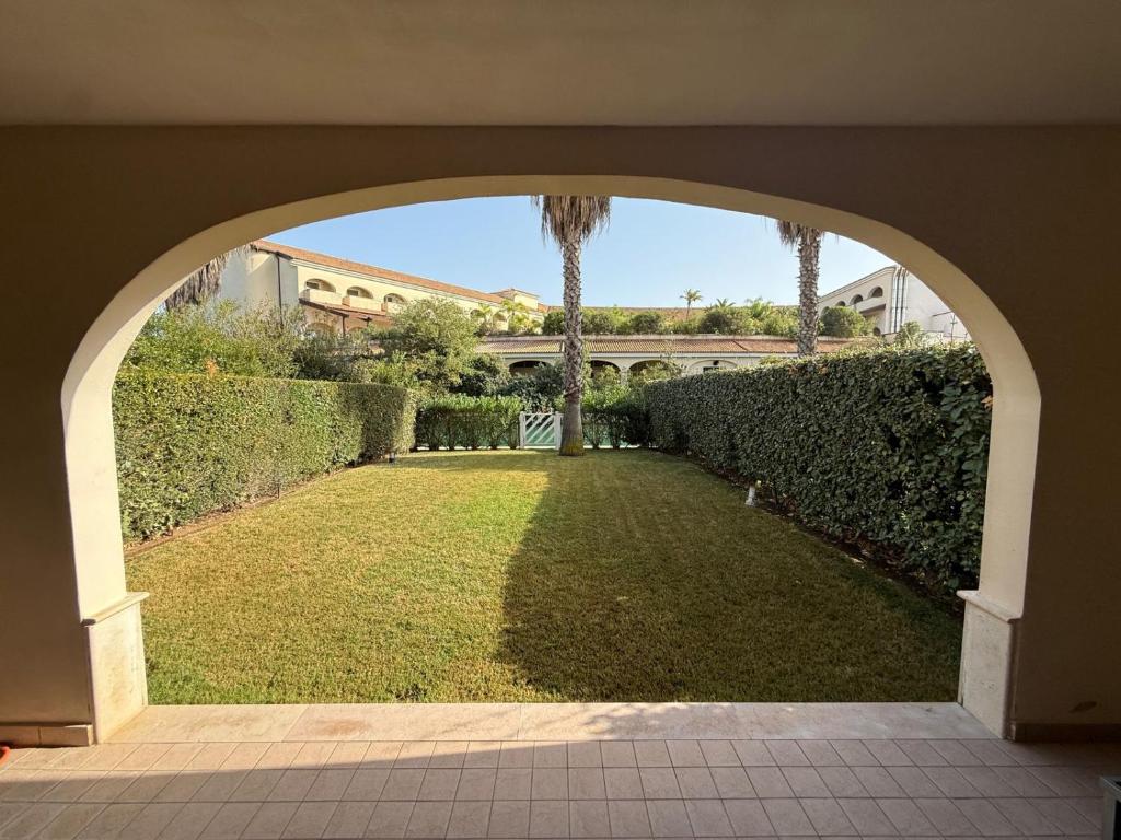 ein Torbogen, der in einen Hof mit Garten führt in der Unterkunft Casa Cousteau in Policoro