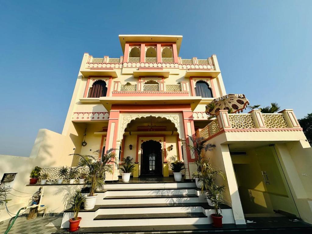 a large house with stairs in front of it at Hotel The Maya Palace in Jaipur