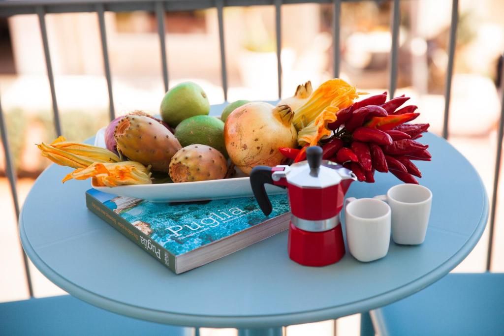 a table topped with a plate of fruit and a book at B&B Portorosso in Monopoli