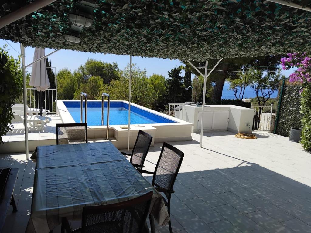a patio with a table and chairs and a swimming pool at Rest House Stiniva in Podšpilje