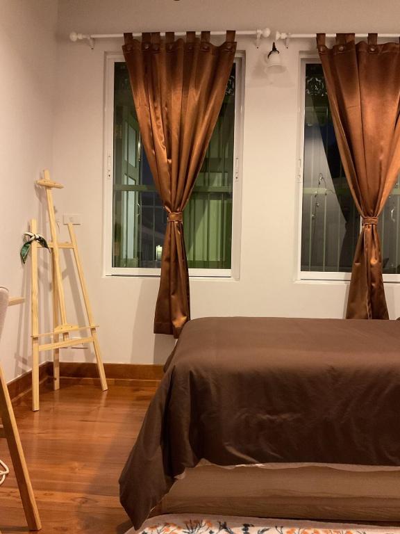 a bedroom with a bed and two windows at Mookda House Chinatown BKK near MRT Samyot in Khlong San