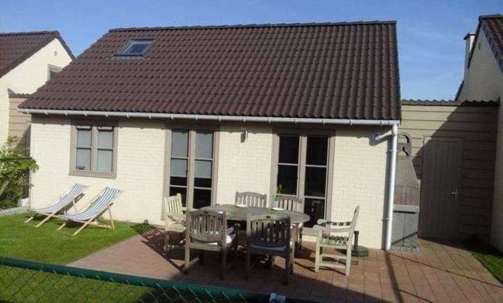 a house with a patio with a table and chairs at Genieten in Wenduine in De Haan