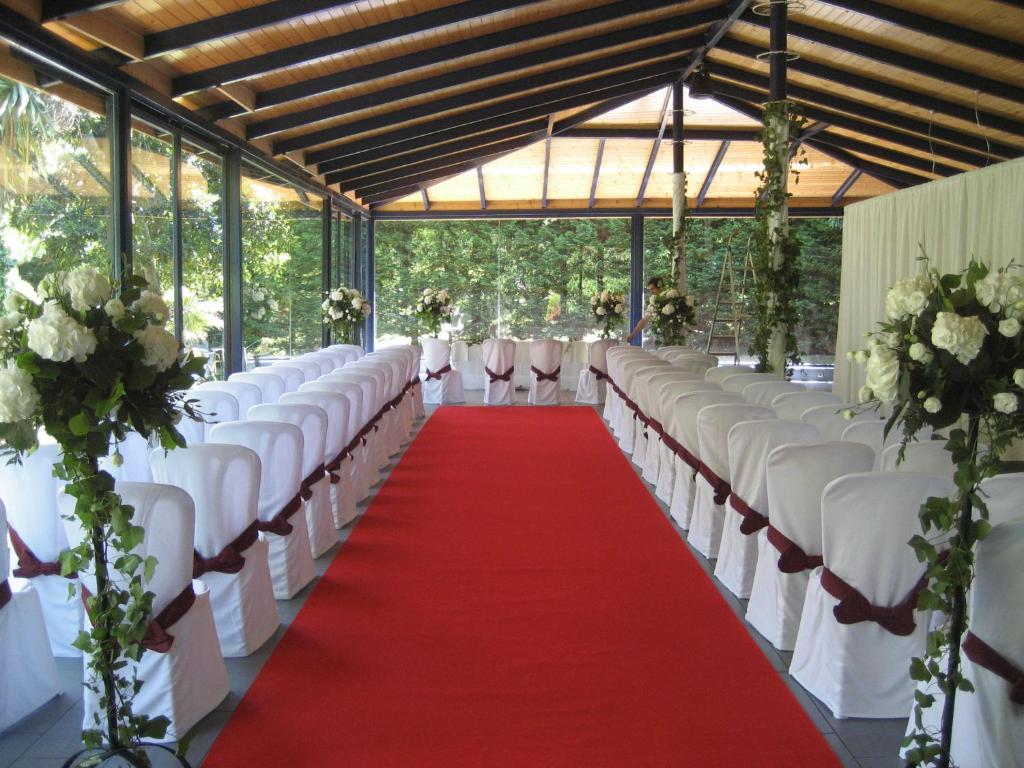 un pasillo largo con sillas blancas y alfombra roja en Hotel Estrella Norte, en Isla