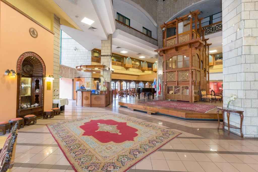 eine große Lobby mit einem Teppich auf dem Boden in der Unterkunft Hotel & Museum Dona Gracia in Tiberias
