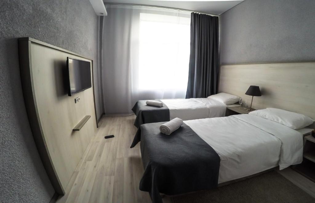 モスクワにあるFili House Hotelのベッド2台とテレビが備わるホテルルームです。