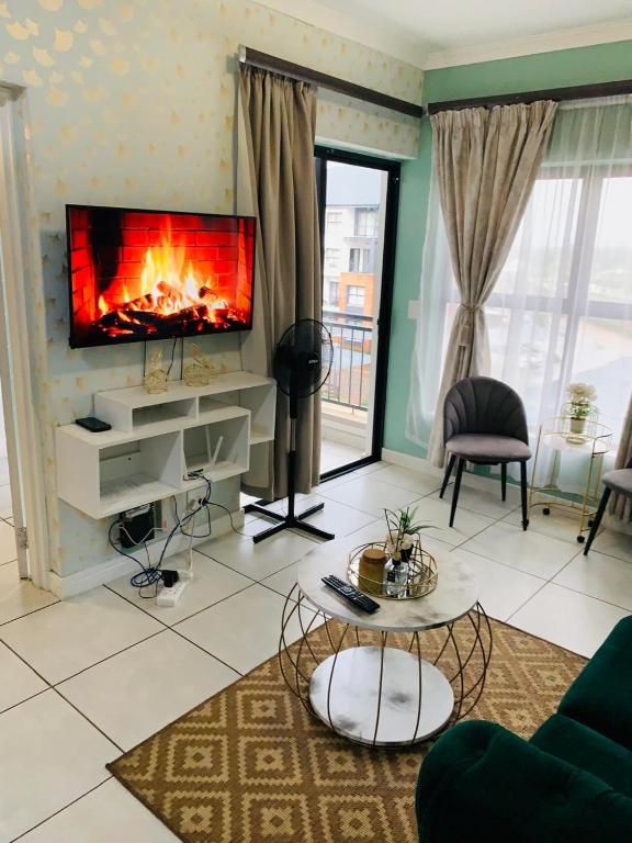 a living room with a fireplace and a tv at The blyde-Luxury one bedroom apartment in Pretoria