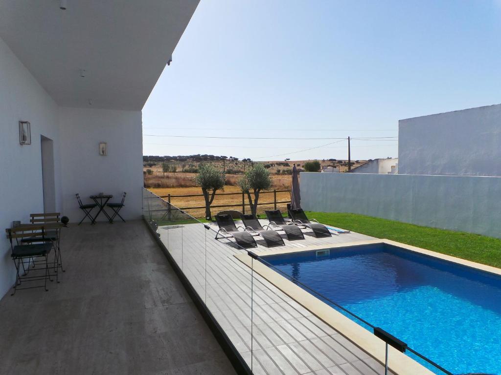 a patio with a swimming pool and lounge chairs at DH Country House in Évora