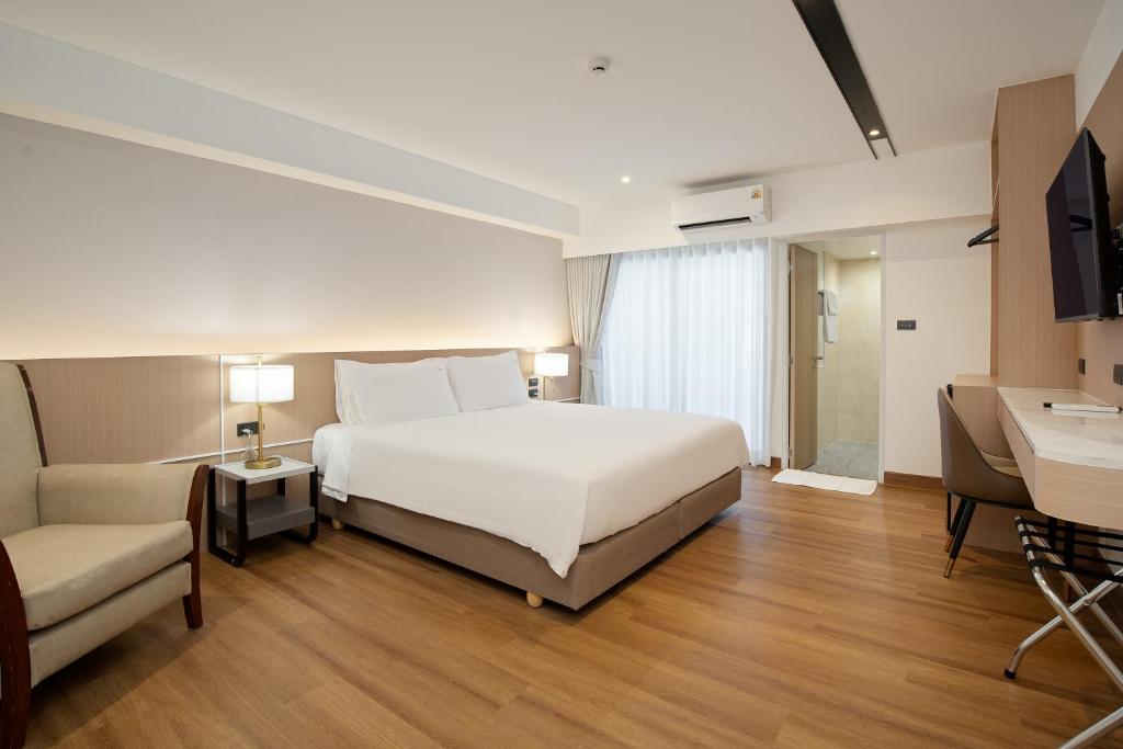 a hotel room with a bed and a couch at P-Park Hotel Bangkok in Bangkok