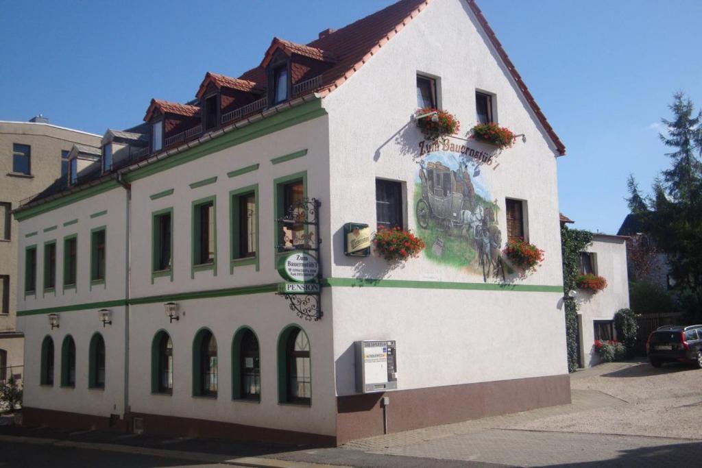 a white building with flowers on the side of it at Pension Zum Bauernstübl in Meerane