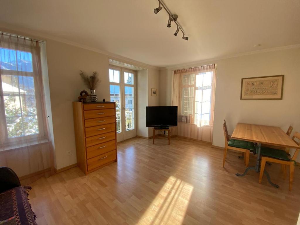 a living room with a wooden table and a television at Bad Ragaz Appartement in Bad Ragaz