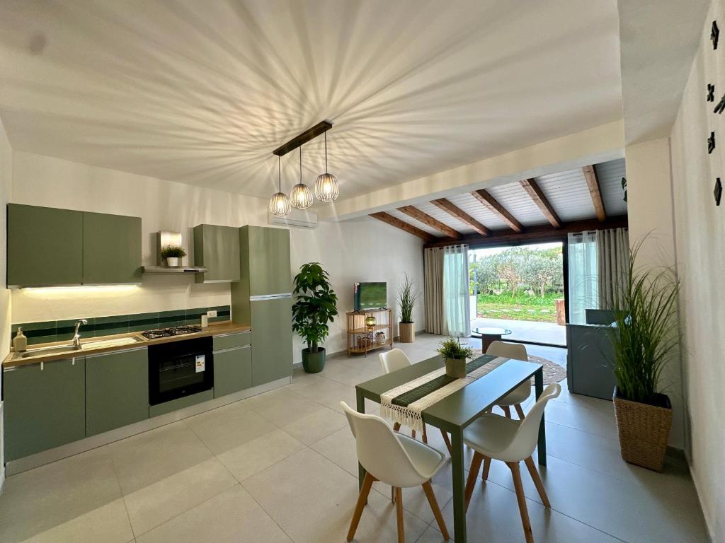 a kitchen with green cabinets and a table and chairs at Casa Manzella Apartments in Cinisi