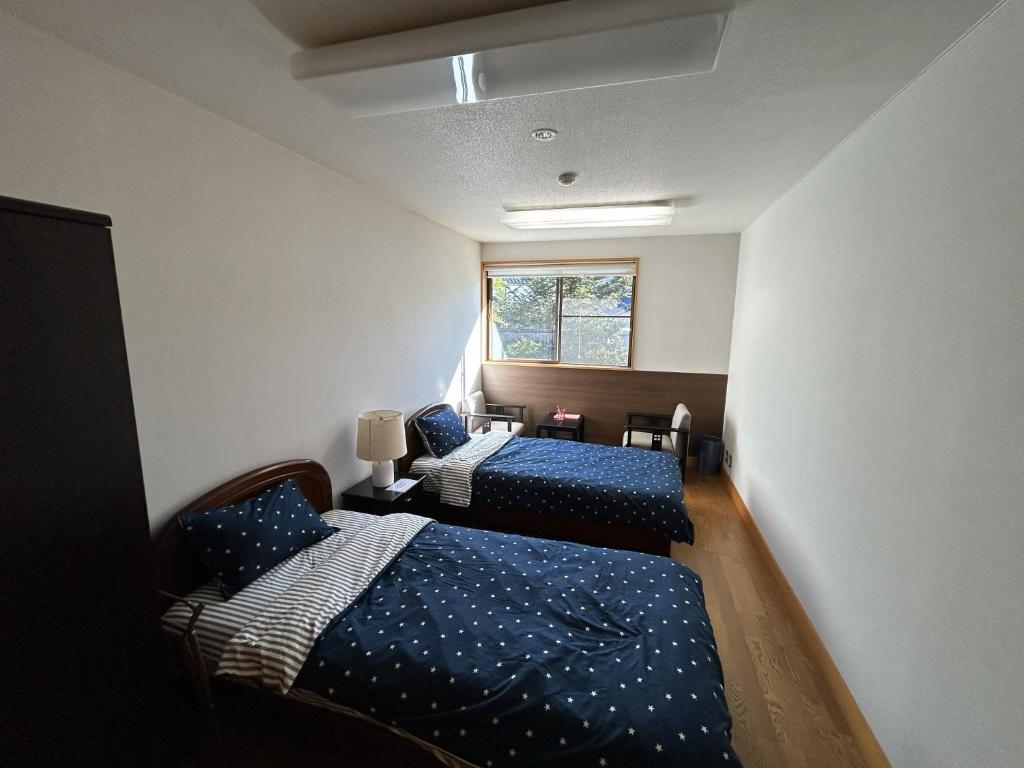 a bedroom with two beds and a window at なかつい陣屋 in Fujita