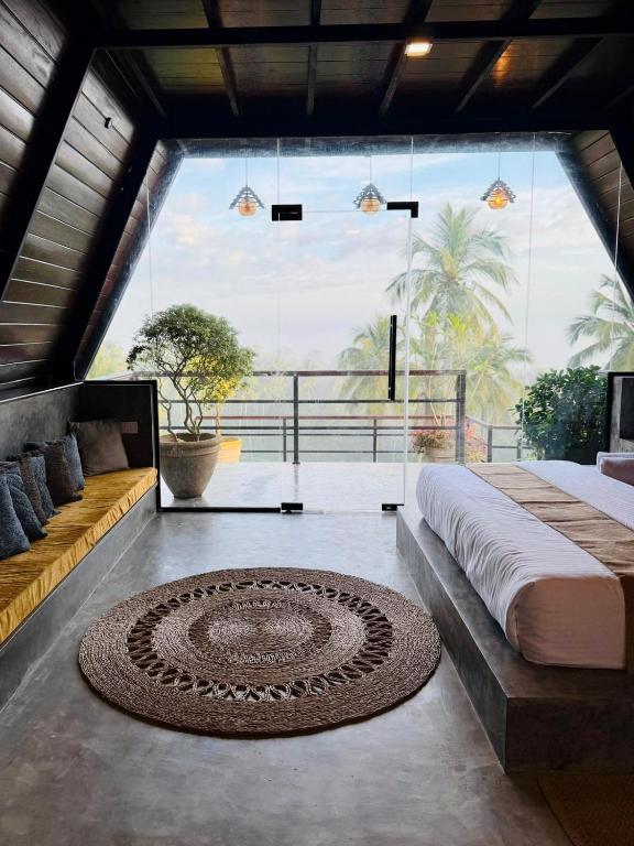 a bedroom with a bed and a large window at Kurunda Estate Villa in Tangalle