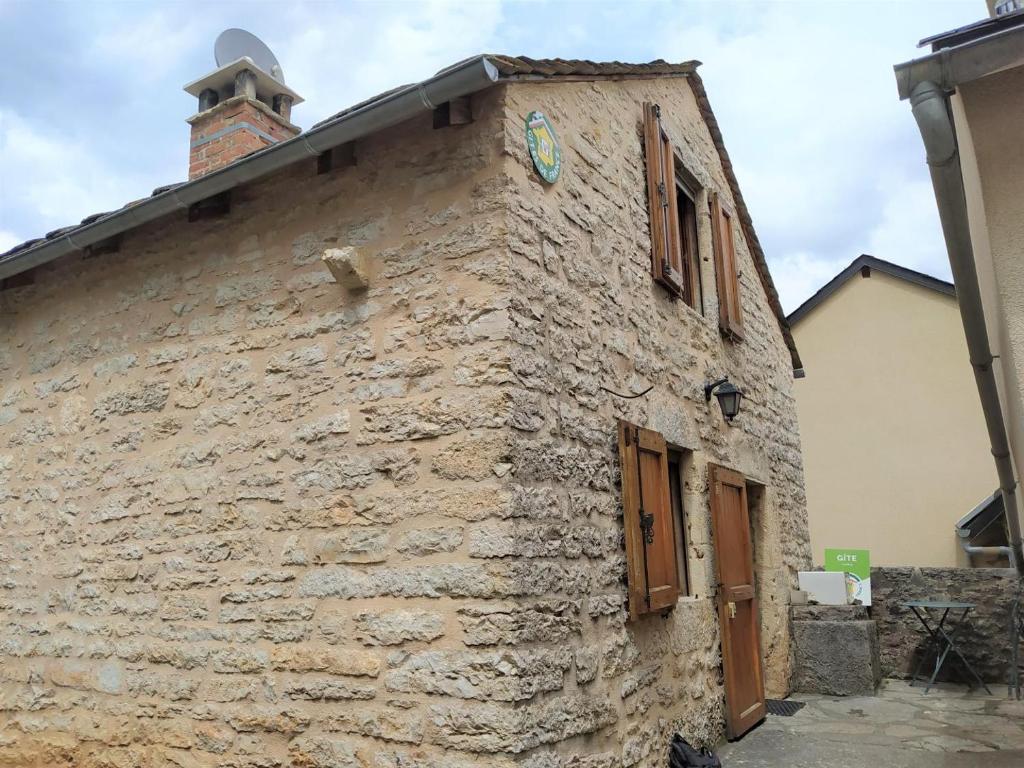 a stone building with a clock on the side of it at Gîte agnès 2/3 personnes in Laval-du-Tarn