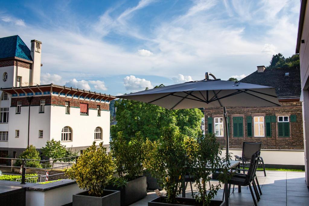 a patio with an umbrella and a building at Residenz Mont Royal in Traben-Trarbach