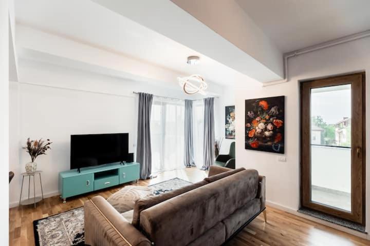 a living room with a couch and a television at Luxury Elegant Pipera New Apartment in Voluntari
