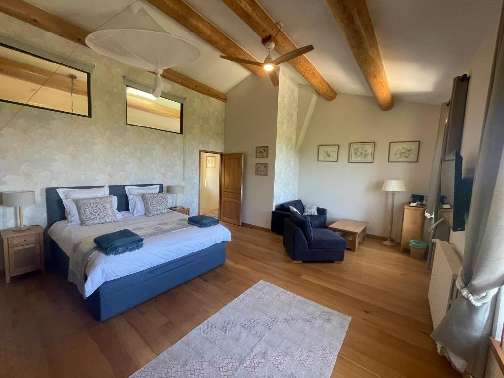 a large bedroom with a bed and a blue chair at Les Yourtes de Provence in Saint-Paulet-de-Caisson