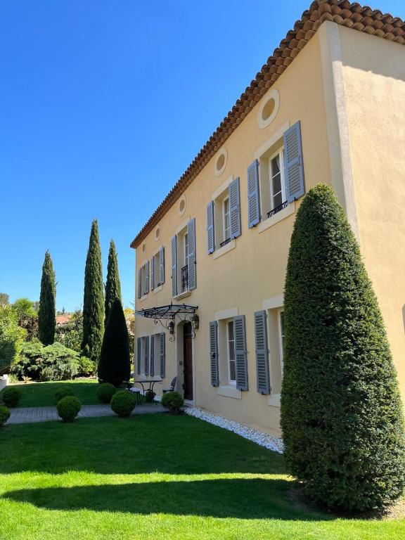 a large house with a hedge in front of it at La Bastide Tara in Cabriès