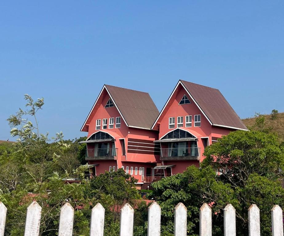 a large red house behind a white fence at ADAM'S FORT by Dell'amore Havn in Vagamon