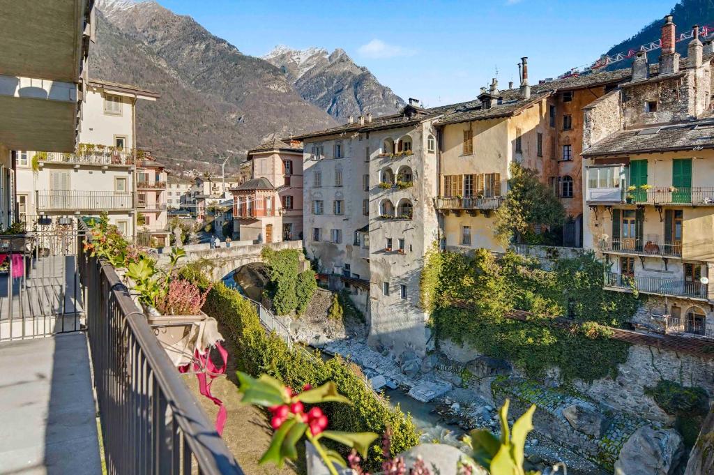 a city with a river and buildings and mountains at Apartment Maira in Chiavenna