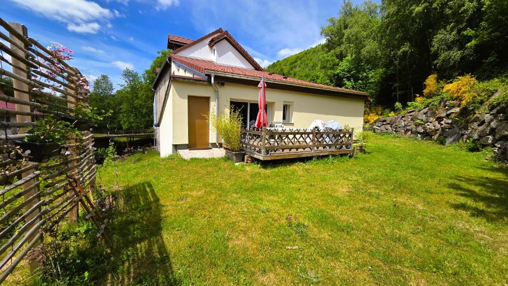 a small house in a yard with a fence at Gîte Le Cincle au cœur du massif des Vosges in La Bresse